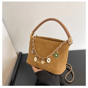 Close-up of brown suede crossbody bag with gold chain and colorful heart charms