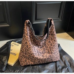 Détail du sac cabas imprimé léopard avec bordure en cuir noir et texture toile