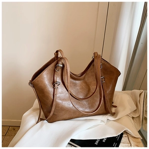 Detailed texture of brown retro faux leather tote bag with silver metal buckles