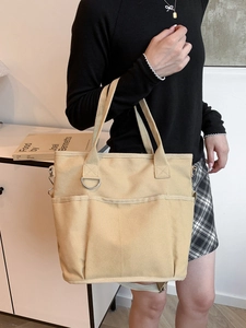Minimalist beige canvas tote bag with multi-pocket design and adjustable shoulder strap
