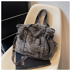 Detail of gray washed denim tote bag showing vintage texture and utility pockets