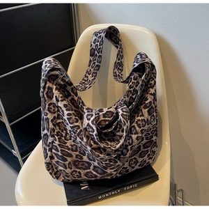 Detail of a large leopard print tote bag on a chair showing durable canvas fabric texture