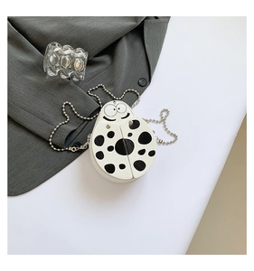 Detail of ladybug shaped mini crossbody bag with black polka dots and metal bead chain strap