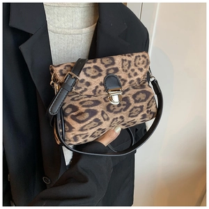 Detail of leopard print faux fur crossbody bag with silver metal buckle and black strap