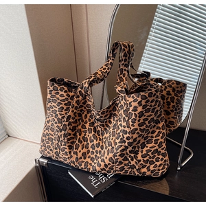 Close-up of leopard print tote bag fabric texture and wide shoulder strap detail