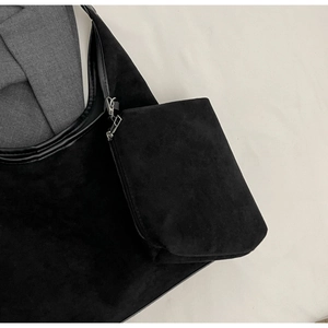 Détail du sac seau en daim noir avec sa pochette zippée amovible et ses finitions en argent chic