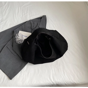 Minimalist black suede tote bag with spacious interior and smooth matte texture finish