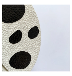 Detail shot of the faux leather material with black animal spots on a white base