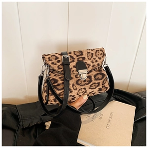 Detail showing the leopard print fabric texture and silver metal twist lock of the crossbody bag
