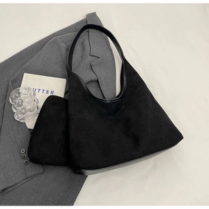 Détail du sac hobo en daim noir avec pochette assortie et finitions en cuir lisse