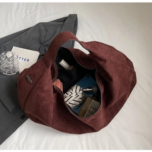 Macro view of burgundy suede tote bag interior showing large capacity and inner pockets