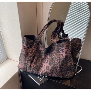 Detail of pink leopard print canvas tote bag with front pocket in stylish home setting