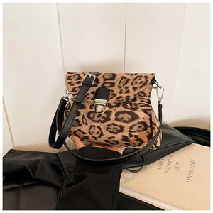 Detail showing the leopard print faux fur texture and black leather strap of this small bag
