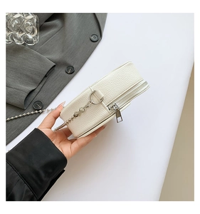 Detail of white lychee pattern PU leather mini bag with silver chain and metal zipper