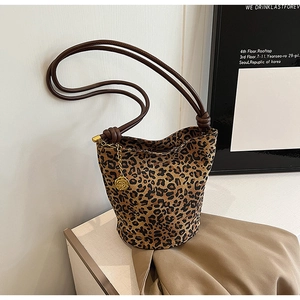 Detail view of leopard print tote bag featuring an elegant gold rose metal charm