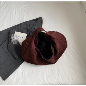 Detail view of burgundy suede hobo bag with zip closure and internal side pocket