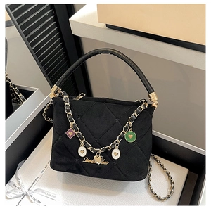 Detail of black quilted handbag with gold Labubee logo and colorful heart charms