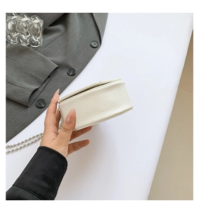 Detail of white pebbled PU leather mini bag showing rich texture and silver ball chain