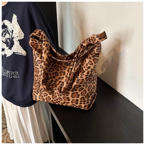 Close-up of a large leopard print tote bag styled with a casual sweater and skirt