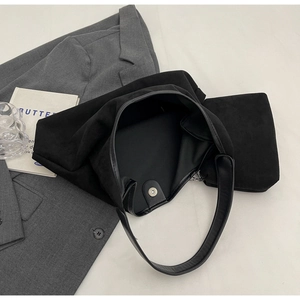 Détail macro du sac cabas en daim noir avec fermoir magnétique et petite pochette