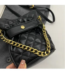 Close-up detail of black quilted bucket bag with luxury gold chain strap and stitching
