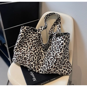 Close-up of leopard print canvas tote bag with thick straps on a white chair