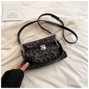 Macro shot of leopard print handbag with silver buckle and black leather strap details
