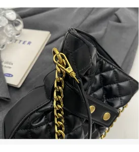 Close-up of quilted black leather texture and luxury gold chain strap on bucket bag