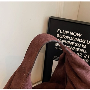 Close-up of wide shoulder strap showing soft suede texture and stitching on tote bag