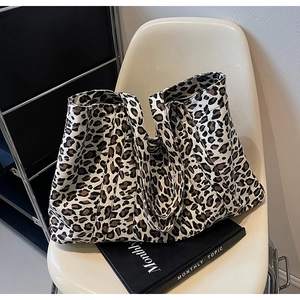 Detail of leopard print tote bag with wide shoulder strap and reinforced stitching texture