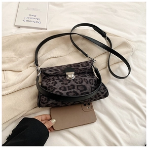 Detail shot of leopard print crossbody bag with silver buckle and phone for scale