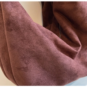Close-up of premium burgundy suede material showing soft texture and fine matte finish