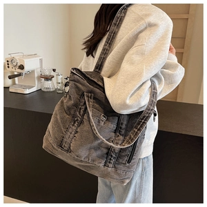 Detail view of large dark grey denim tote bag with hand straps and adjustable shoulder strap