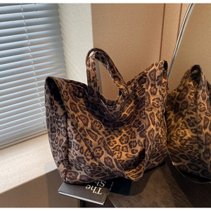 Detailed view of large leopard print canvas tote bag with dual shoulder straps and handles