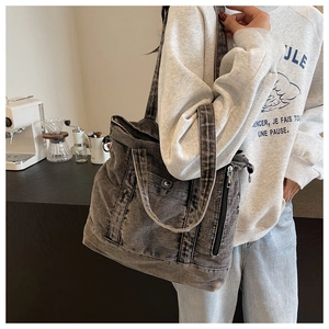 Detailed view of the vintage grey denim tote bag with side zippers and wide shoulder straps
