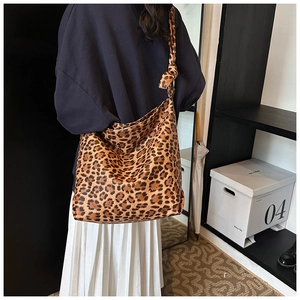 Detail of hobo bag featuring bold leopard print and stylish knotted shoulder strap