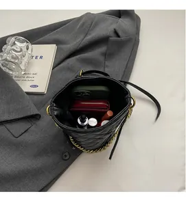 Interior view of black quilted bucket bag showing storage for phone and cosmetics