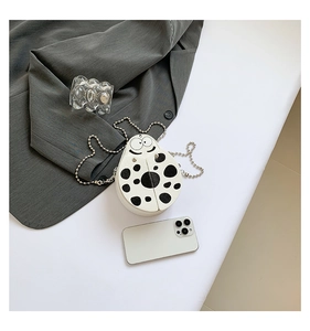 Close-up of ladybug crossbody bag with black polka dots and metallic chain strap