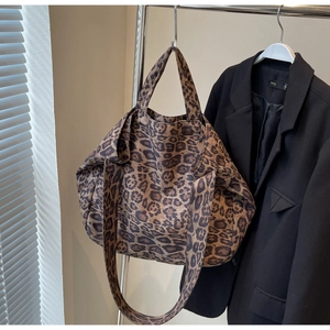 Macro shot of large leopard print tote bag hanging on a rack for daily fashion use