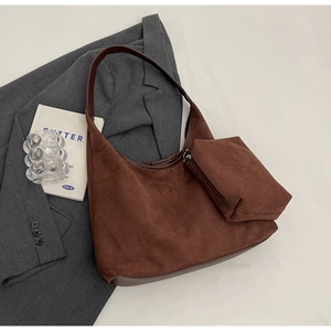 Détail du sac à bandoulière croissant en daim marron foncé avec pochette zippée assortie