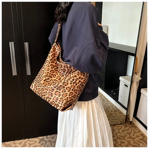 Detailed back view of a large leopard print canvas tote bag on a model shoulder
