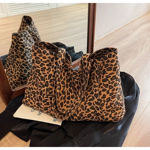 Detailed view of leopard print canvas tote bag on silk fabric with mirror reflection
