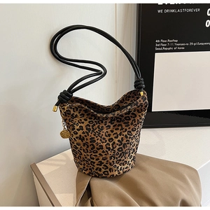 Close-up of leopard print canvas tote bag with black rope strap and golden rose charm