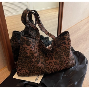 Detailed close-up showing the large capacity and leopard print texture of the tote bag