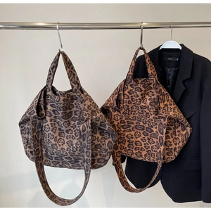 Detail of two leopard print tote bags in grey and brown tones with wide shoulder straps