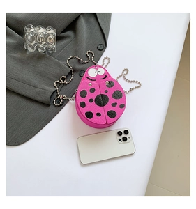 Detail of pink ladybug mini PU leather crossbody bag with beaded chain and cartoon eyes