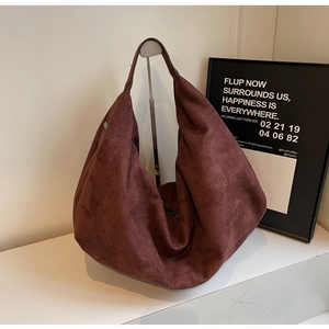 Detail of large brown hobo tote bag with matte suede texture and soft draping silhouette