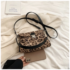 Detail of leopard print crossbody bag with silver buckle and black leather shoulder strap