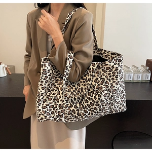 Detailed view of large leopard print tote bag being worn by a model in a lifestyle setting