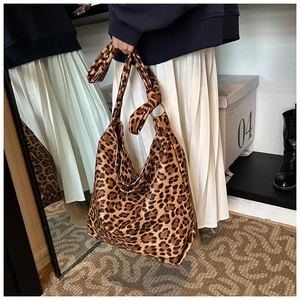 Close-up of leopard print canvas hobo bag with knotted strap and gold metal ring detail